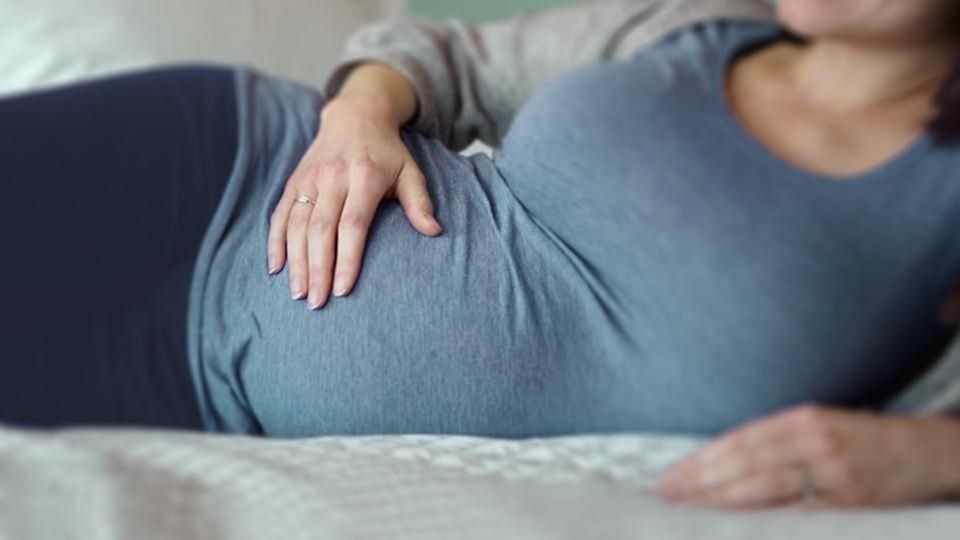 a picture of a pregnant woman laying down