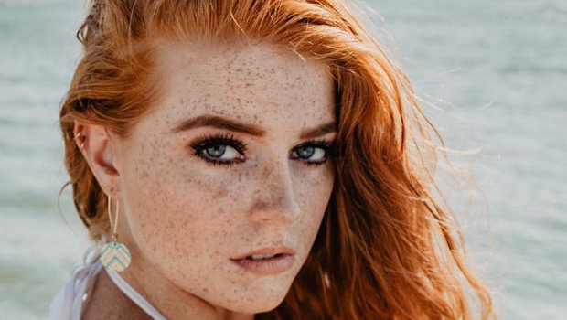 a picture of a female who has red hair and has tanned skin