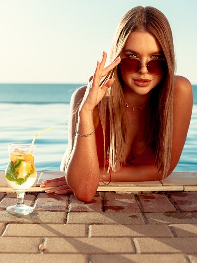 a woman sunbathing at the pool wearing sunglasses